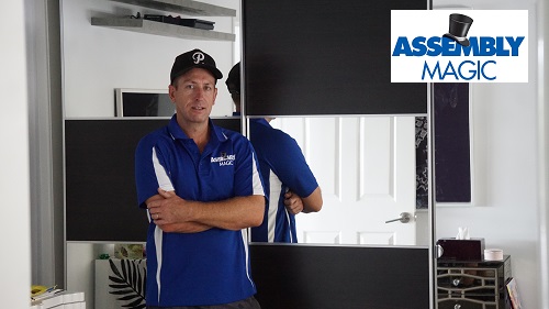 Technician - Ben in front of a mirror cabinet with Assembly Magic logo in top right corner