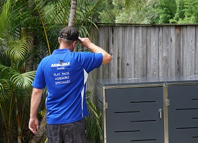 Technician - Ben, in front of a flat pack bin shed