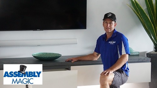Technician - Ben in front of a floating cabinet he installed with under lighting