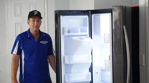 Technician - Ben in front of a refrigerator