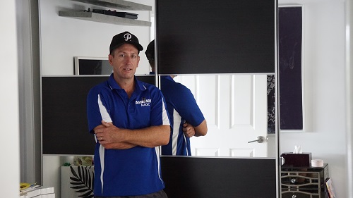 Technician - Ben in front of a large mirrored wardrobe