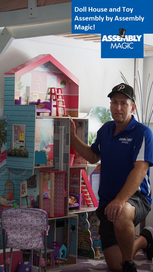 Technician - Ben with a large dollhouse he assembled.