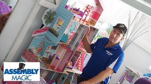 Technician - Ben with a newly assembled Dollhouse. Logo in bottom left corner