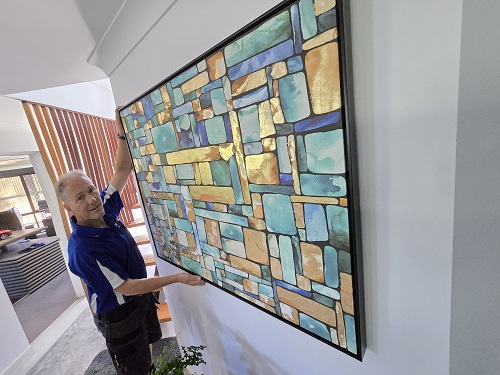 Technician mounting artwork for a client