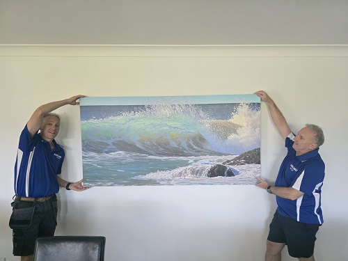 Technicians hanging a canvas.