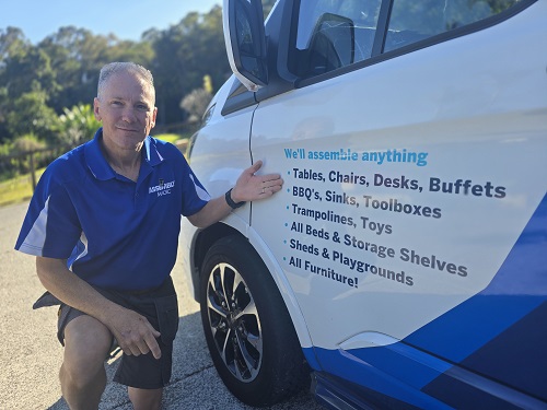 Technician - Robert - pointing to his services on the side of his van.