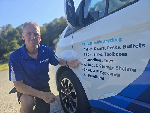 Technician - Robert, pointing to his Bed Assembly service on the side of his van