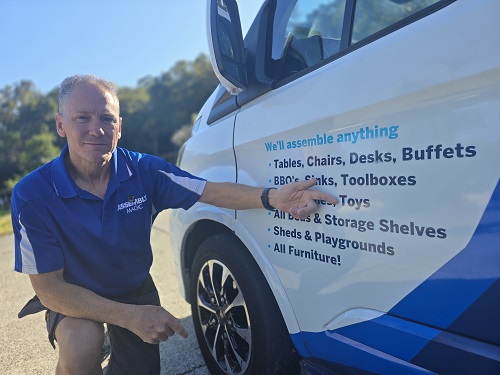 Technician - Robert, pointing at his Toy assembly service on side of his van