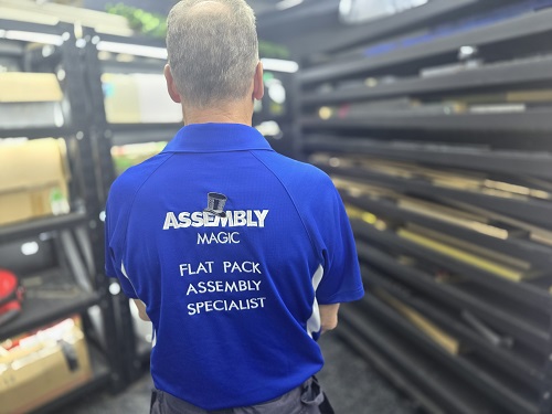 Technician showing the back of his Assembly Magic shirt.