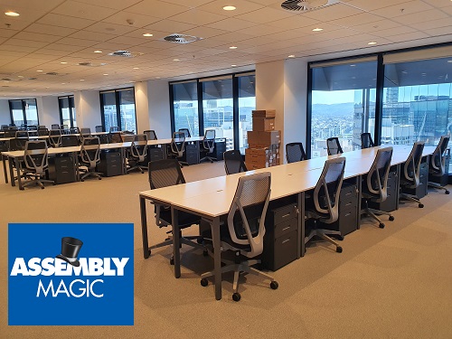 Large room full of Office furniture, assembled by Assembly Magic. Logo in bottom left corner.
