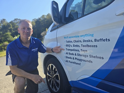 Technician - Robert, pointing at his Trampoline assembly service in the side of his van