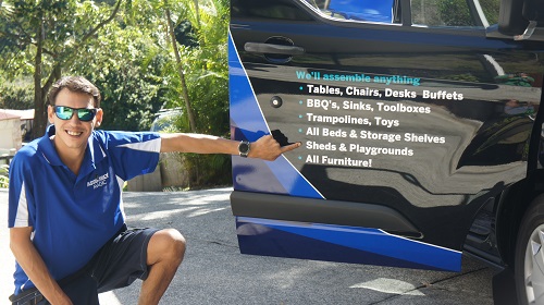 Technician - Shaun, pointing to his services on the side of his van.