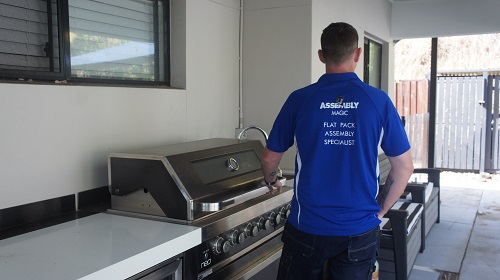 Technician with an outdoor kitchen he assembled.