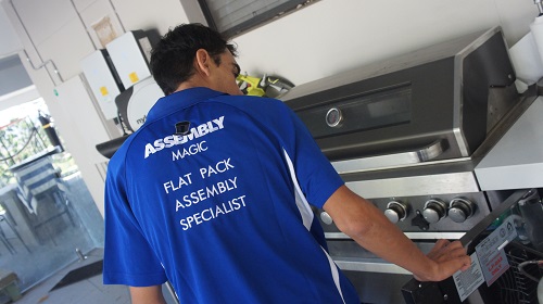Technician with a BBQ he installed in a Wynnum pool yard.