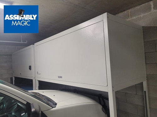 Car beneath an Assembly Magic over bonnet storage unit. Assembly Magic logo in top left corner